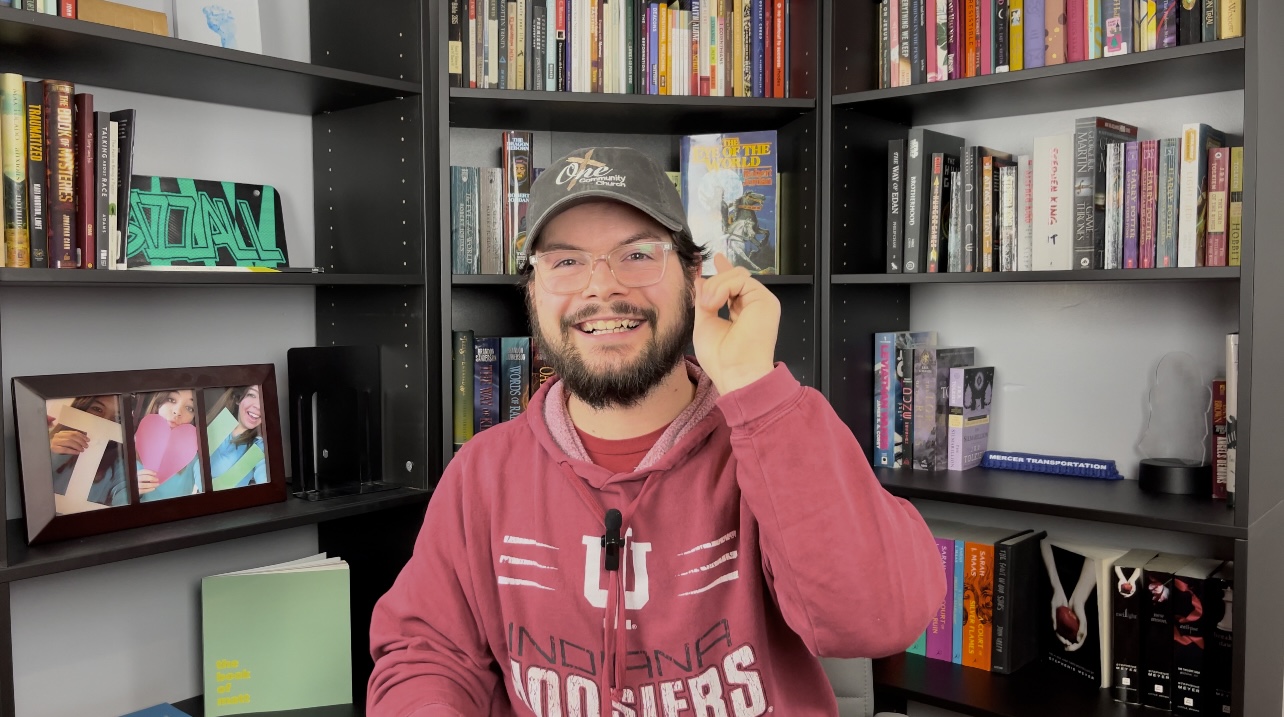 Matthew Bramer standing in front of a bookshelf